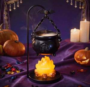 Halloween cauldron lamp in seasonal setting with pumpkins and candles