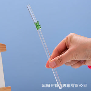 Transparent colored bear glass reusable drinking straws with gummy bear charms on a cup