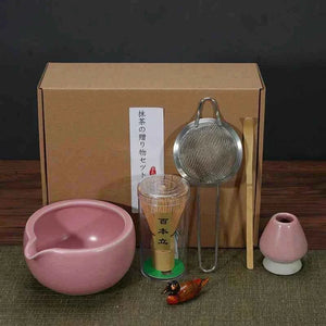 Japanese tea set for Maccha ceremony with pink bowl, whisk, strainer, and accessories.