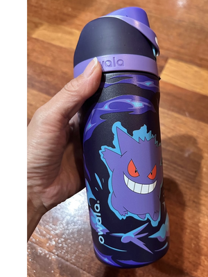 Hand holding Owala Gengar water bottle in purple, side view