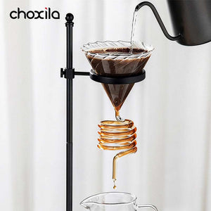 Choxila Snake Tube glass coffee dripper with amber spiral tube on wooden base and black metal stand for slow-drip pour-over brewing