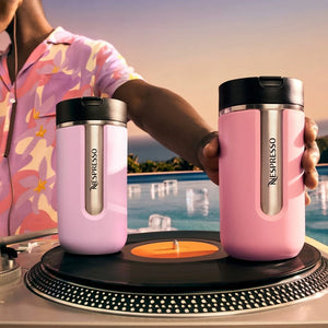 Two pink insulated travel mugs on reflective surface