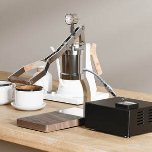 Aleman 2s Hand Press Espresso Machine with wooden accents and stainless steel body on coffee shop counter