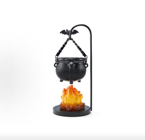 Angled view of Halloween cauldron lamp showing flame detail at base