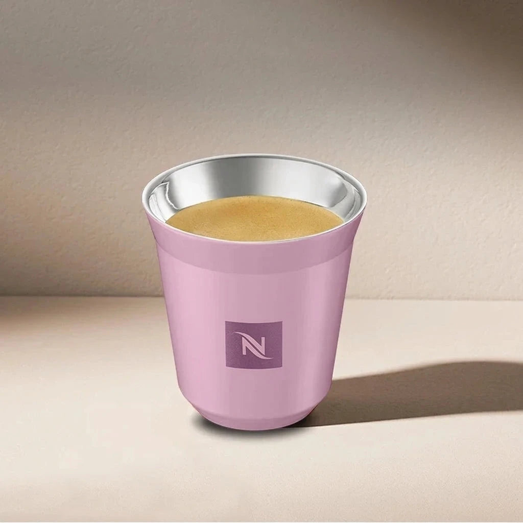 Pink Nespresso Swarovski espresso cup filled with coffee, angled view