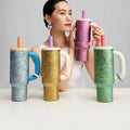 CHaKOLAB pure titanium insulated tumbler with straw, model holding pink tumbler with blue, yellow and green tumblers