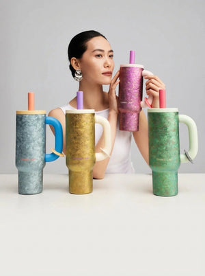 CHaKOLAB pure titanium insulated tumbler with straw, model holding pink tumbler with blue, yellow and green tumblers