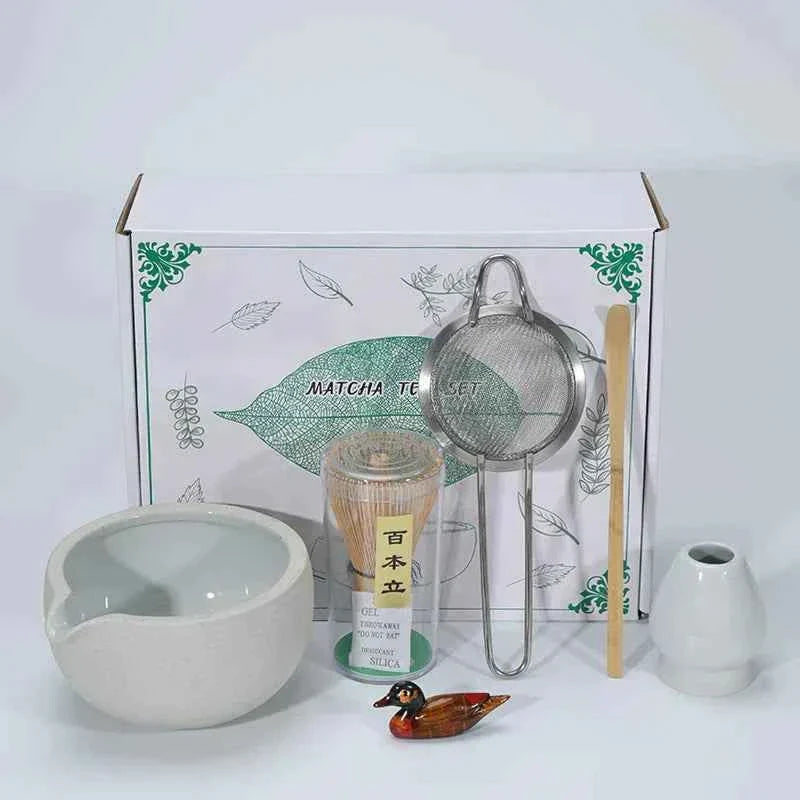 Japanese ceramic matcha tea set with bowl, whisk, sifter, and decorative items.