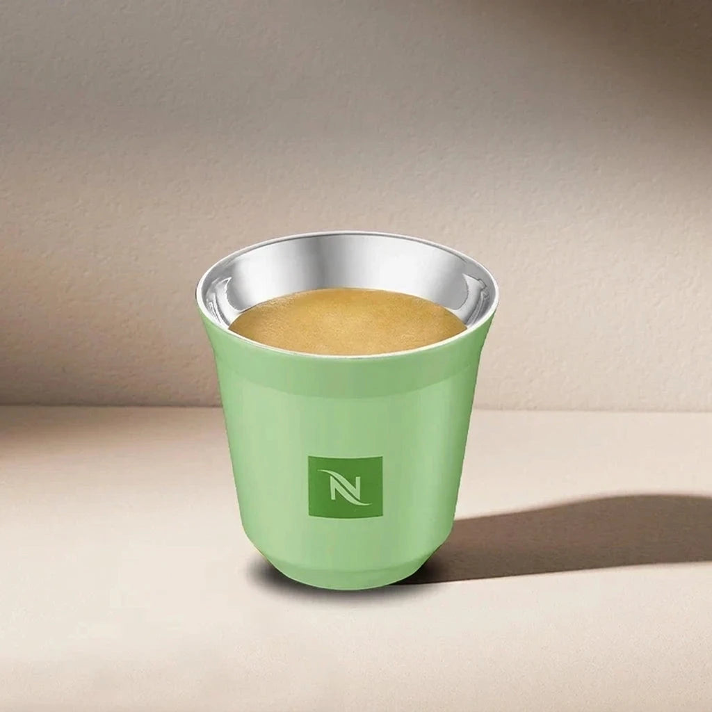 Green Nespresso Swarovski long cup filled with coffee, angled view