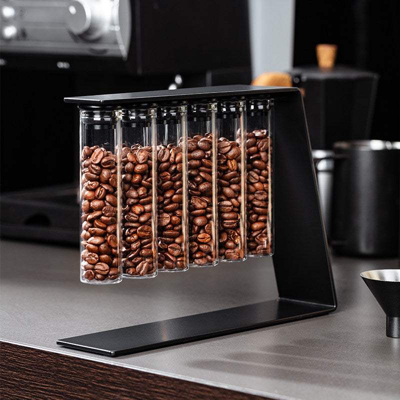 Magnetic coffee bean storage tubes with metal stand and stainless steel funnel on kitchen counter