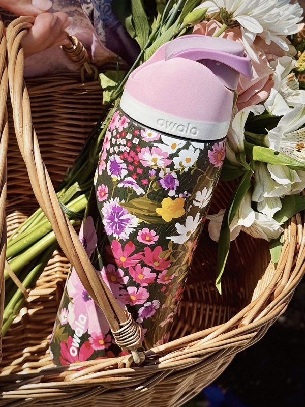 Owala FreeSip floral print water bottle in wicker basket with flowers