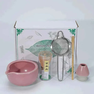 Japanese Maccha tea set with pink ceramic bowl, bamboo whisk, tea sifter, and tools.