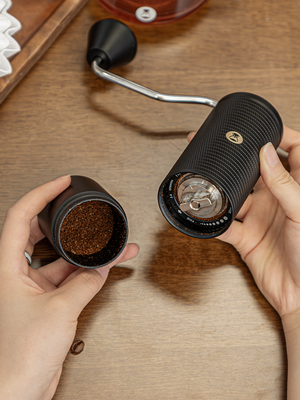 Compact manual coffee grinder with stainless steel burr and ergonomic handle for precise coffee grinding