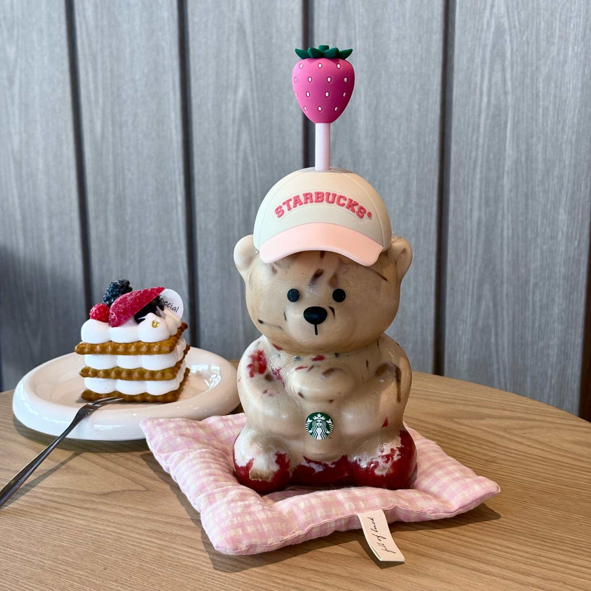 Top view of the Starbucks bearista cup pink showing the removable pink hat lid and strawberry-themed accessories.