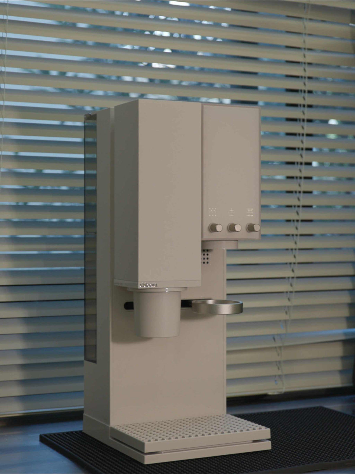 xBloom Studio white smart brewer in a natural light setting near a window.